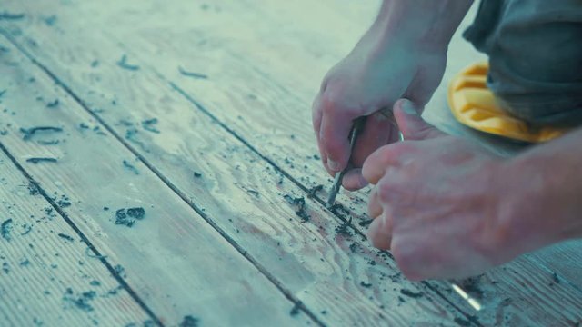 Cleaning out gaps between wooden boat deck plank ridges to re-caulk douglas fir timber real time medium close up
