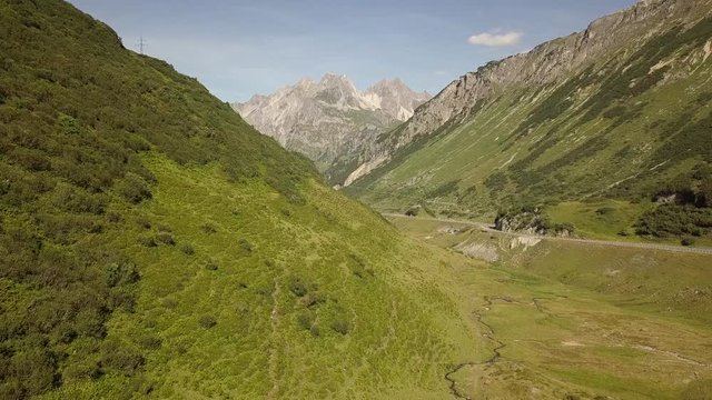 Aerial view of a road in the Austrian Alps, in the Arlberg region, between Vorarlberg and Tyrol, on a sunny summer day.