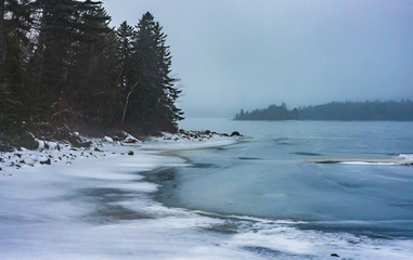 Winter lake shoreline on a misty day in Halifax, Nova Scotia, frozen, foggy.