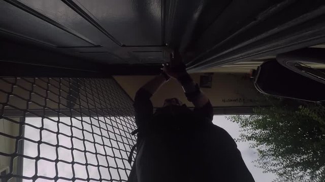 Person walking indoors on a cloudy day, opening the fly-screen, then closing the fly-screen. View from underneath,