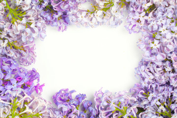 Frame of spring lilac flowers with space for text on white background. Flat lay, top view, copy space. Tender postcard composition. Spring floral concept.
