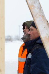 Two workers in overalls at a construction site