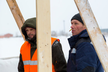 Two workers in overalls at a construction site