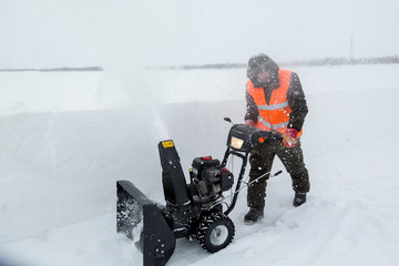Worker operator snow plow on snow removal
