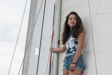 young teen girl standing on the boom of a saillboat © David