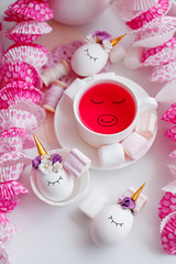 kawaii tea cup with cutest funny eyes and unicorn eggs and sweets on festive background, cute...