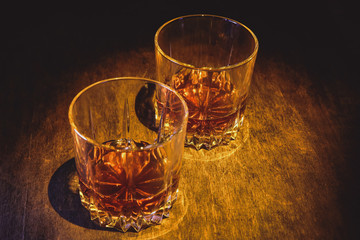 Whiskey in a glass on a dark wooden background.