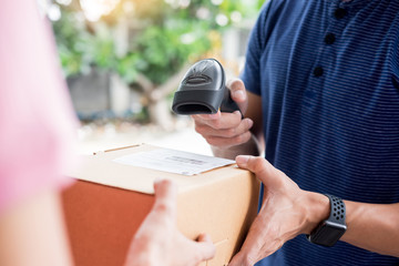 delivery service concept, customer hand receiving a cardboard boxes parcel from delivery man at home.