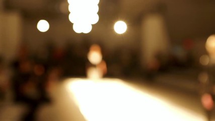 Models at New York Fashion Week walking on the catwalk runway out of focus.