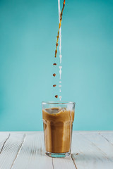 Coffee and plant based milk pouring in a glass