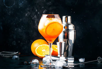 Aperol spritz cocktail in big wine glass, summer Italian low alcohol cold drink, dark bar counter...
