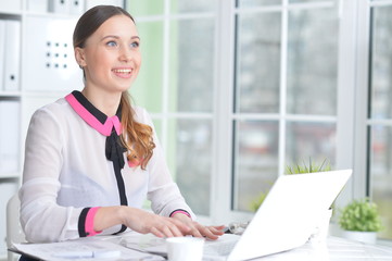 Portrait of young beautiful woman working in office