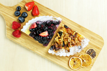 fruit tart with berries and nuts on wood table