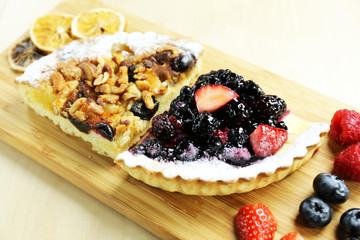 fruit tart with berries and nuts on wood table