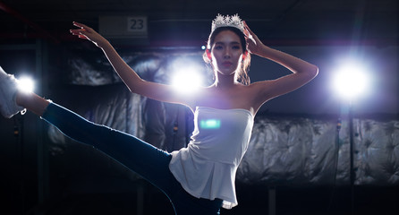 Asian Fitness Miss Beauty Contest exercise warm up ballet dance stretch body arm legs Smoke Dark background environment with silver diamond crown, studio lighting rim back light low exposure © Jade