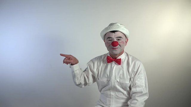 Emoji Clown. A clown with ironic laughter indicates with his hand the expulsion of someone insistently five times by helping himself with a megaphone.