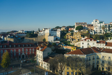 Fototapeta na wymiar Beautiful panoramic Lisbon landmark with tiny houses with moorish architectural elements on the hill; drone view of picturesque labyrinth of narrow streets and small squares in early morning, Portugal
