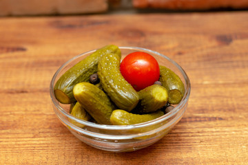 Pickles in the glass jar on the wooden table