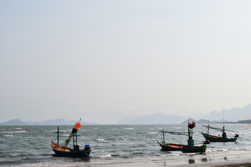 Group of Fishing boat on the beach , Ocean waves splash the shore severely , Sea on the windy day , Bay with mountain at Sam Roi Yot beach , Thailand