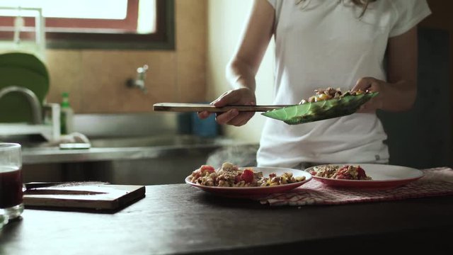 Girl serving a food on village kitchen