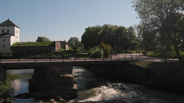 Flying over the rapids looking out over the old castle (Nykopingshus) Nykoping, Sweden. Aerial in slowmotion