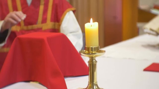 Priest uncovering and preparing chalice at altar
