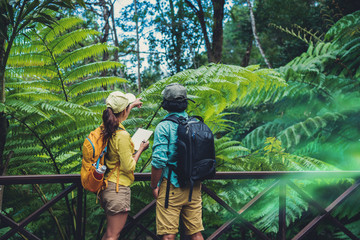 Asian couple travel nature walking relax and studying nature in the fores...
