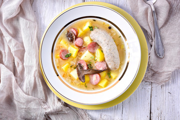 a polish easter soup with homemade white sausage and mushrooms