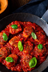 Baked mini meatballs in tomato sauce with basil