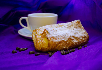 cup of coffee, grains of coffee with a bun on a purple background