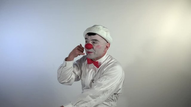 Emoji Clown. A mime clown asks to wait for him to finish the conversation over the phone.