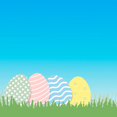 Decorative Easter eggs on green grass, with copy space