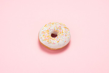 Fresh tasty sweet donut on a pink background. The concept of fast food, bakery, breakfast, sweets. Minimalism.