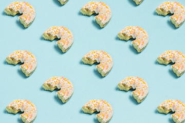 Bitten Fresh tasty sweet donut on a blue background. Fast food concept, bakery, breakfast. Minimalism. Pattern.