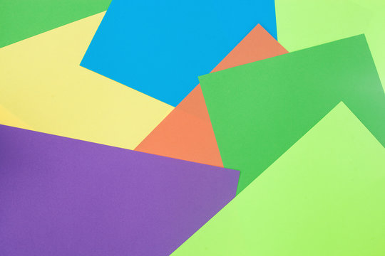 Colorful background. Sheets of colourful paper on the desk top view. Abstract background