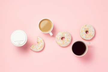 Fototapeta na wymiar Cups and paper cup with coffee or tea, Fresh tasty sweet donuts on a pink background. Fast food concept, bakery, breakfast, sweets, coffee shop. Flat lay, top view, copy space.