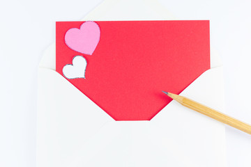 White triangle envelope opened with red letter inside, two hearts and wooden pencil near Valentine's day or festive concept Letter or invitation inside Minimalist concept Copy Space and template.