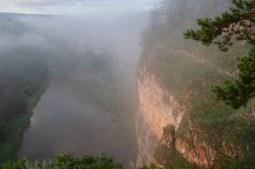 The morning mist rises over the river canyon