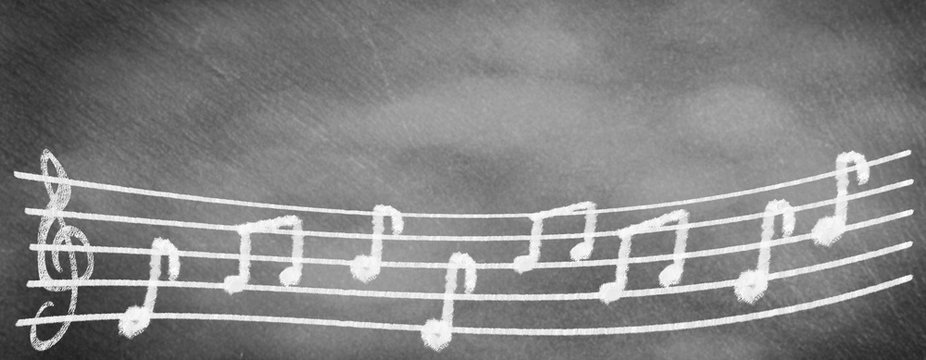 Musical staves with clef and notes on school blackboard
