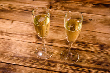 Two wineglasses with champagne on wooden table