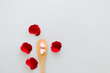 Two marshmallow shape heart  on wood spoon and rose isolated on white background
