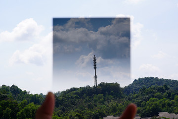 A Man hand holding gradual Neutral Density filter pointing at the sky