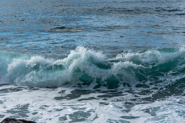 Turquoise Blue Wave Breaking and Washing into Shore in Italy