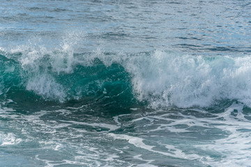 Turquoise Blue Wave Breaking and Washing into Shore in Italy