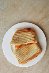 Grilled cheese sandwich for breakfast on rustic wooden table, top view.