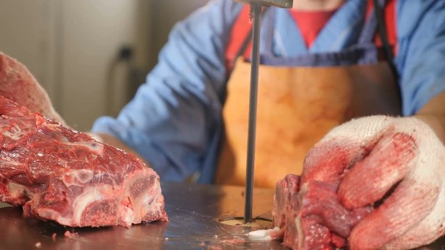 Meat processing factory. Closeup shot of a Saw for meat. Factory modern equipment. Meat factory. Man worker cutting raw meat on a steel band saw machine. 4k