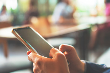 Woman hand using smartphone in cafe shop background. Business, financial, trade stock maket.
