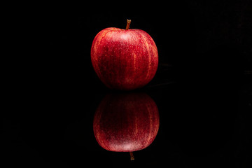 red apple on black background reflection