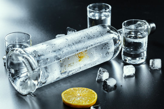 Cold vodka in shot glasses on a black background.