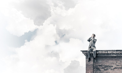 Young man on building edge do not want to see anything